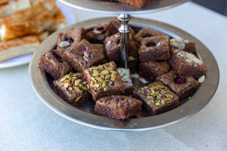 Chocolate brownies with almonds and pistachios on a plateの写真素材
