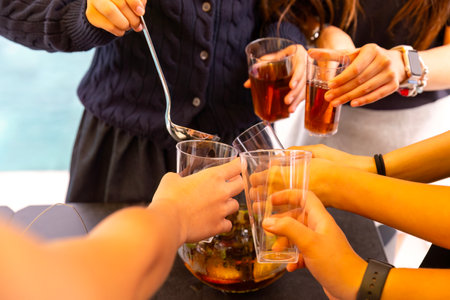 Close-up of a group of friends clinking glasses with drinksの写真素材