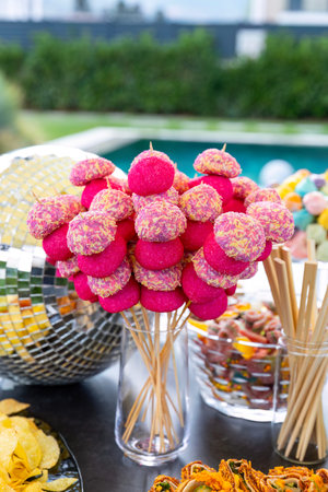 Colorful candies on sticks in a vase on the table