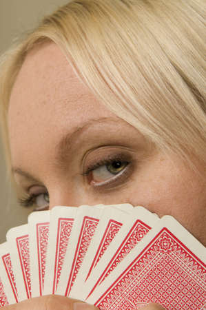 Young Woman Holding Playing Cards close to eyesのeditorial素材
