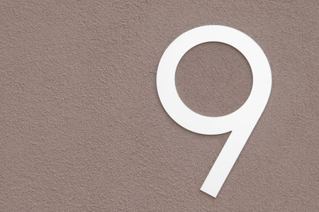 Number 9  mounted to a masonary wall