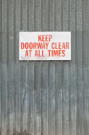A Keep Doorway clear sign mounted to a metal wallの写真素材