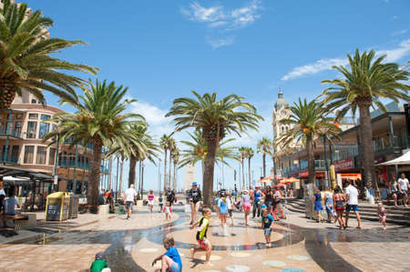 Adelaide, Australia - January 09, 2016: Children playing in the water feature at Moseley Square, Glenelg. Glenelg is the very popular seaside suburb of Adelaide, South Australia. On warm days tourists and locals flock to the area for shopping, entertainmeのeditorial素材