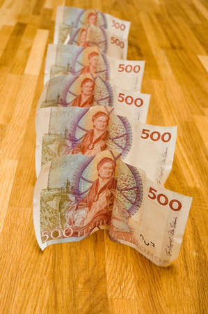 Six Swedish 500 kronor bills are spread out on a wooden background.の写真素材