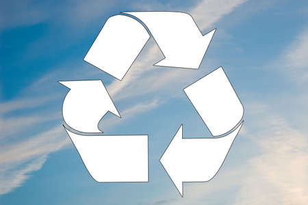 A white recycle symbol is set against a blue sky.の写真素材