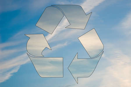 A recycle symbol made out of clouds is set against a blue sky.の写真素材