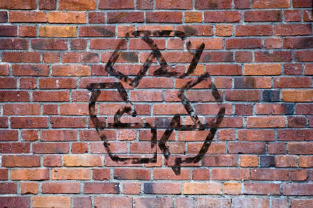 A recycle sign made up of grafitti letters against a brick wall, could be used as environmental, green or ecoogical imagery.の写真素材