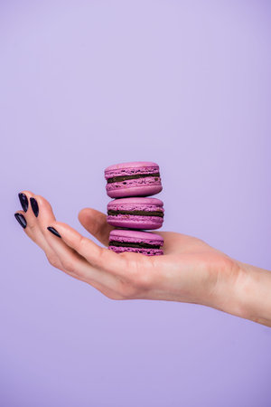woman holding macarons isolated violet