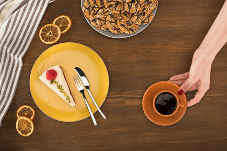 hand with coffee and dessert