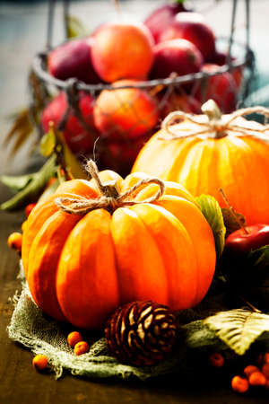 Autumn still life with pumpkins, apples and leaves on old wooden backgroundの写真素材