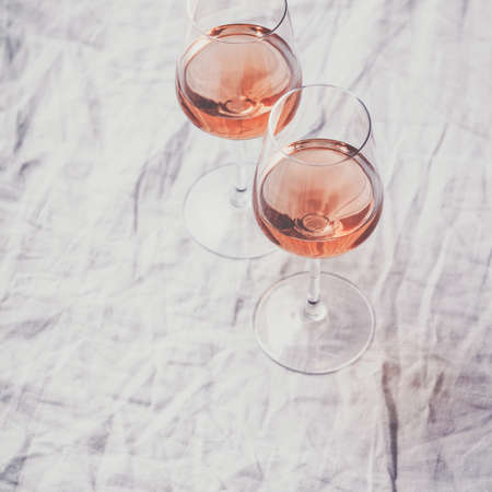 Rose wine in glasses on white linen clothの写真素材