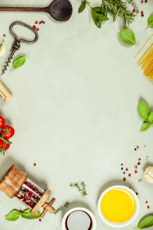 Olive oil, balsamic vinegar, salt, pepper, herbs, pasta, tomatoes on concrete backgroundの写真素材