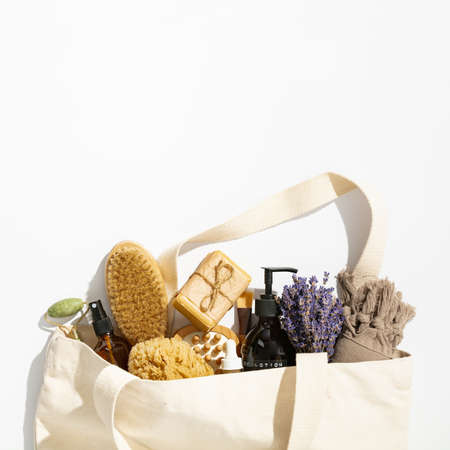 Eco-friendly cotton reusable bag with natural skin care products on white background, flat layの写真素材