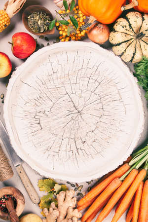 Healthy food cooking background. Fresh garden carrots, pumpkins, onions, apples and spices on rustic backgroundの写真素材