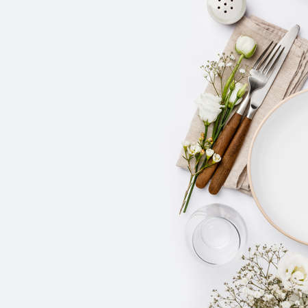 Empty white plate and cutlery on a napkinの写真素材