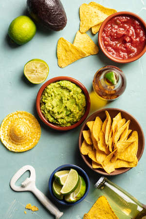 Nachos, guacamole, salsa and beer on blue backgroundの写真素材