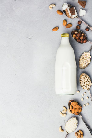 Vegan milk and ingredients on rustic background, flat layの写真素材