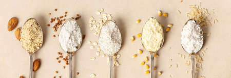 Metal spoons of various gluten free flour almond flour, oatmeal flour, buckwheat flour, rice flour, corn flour , flat lay, top viewの写真素材