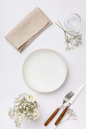 Empty white plate and cutlery on a napkinの写真素材