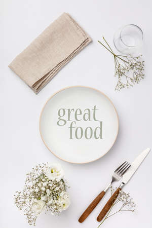 Empty white plate and cutlery on a napkinの写真素材