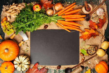 Healthy food cooking background. Fresh garden carrots, pumpkins, onions, apples and spices on rustic backgroundの写真素材