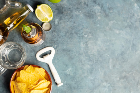 Nachos and beer on blue background, flat lay