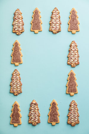 Christmas gingerbread cookies in the shape of a Christmas tree on blue background