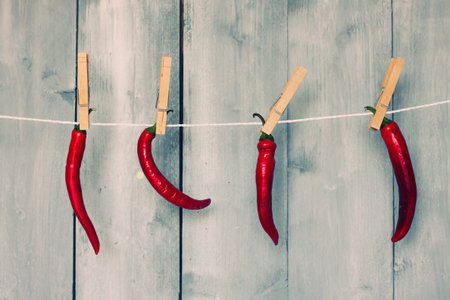 Photo of 4 hanging red chili pepper