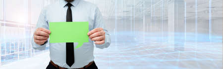 Businessman Holding Empty Page Chat Box With Both Hands Around Futuristic Technology. Employee Presenting Blank Workbook Surrounded By Modern Automation.の写真素材