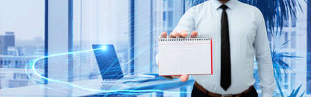 Picture Of Businessman Holding Empty Page Graphing Notebook Around Futuristic Technology. Employee Presenting Blank Workbook Surrounded By Modern Automation.の写真素材