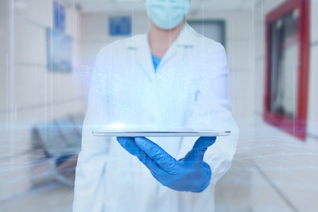 Doctor In Uniform Standing Holding Tablet And Virtually Typing With Pen. Nurse Carrying Pad Typing And Displaying New Medical Futuristic Technologies.の写真素材