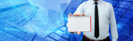 Picture Of Businessman Holding Empty Page Graphing Notebook Around Futuristic Technology. Employee Presenting Blank Workbook Surrounded By Modern Automation.の写真素材
