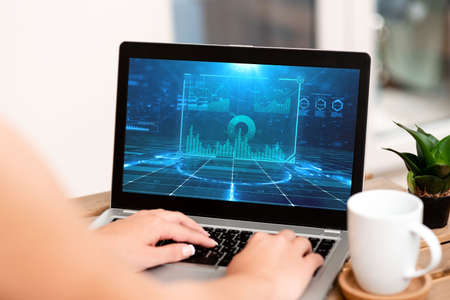 Hand Of Woman Typing On A Laptop Beside Coffee Mug And Beautiful Plant Accomplishing Work From Home. Girl S Arm Making New Projects Finishing Remote Jobs.の写真素材