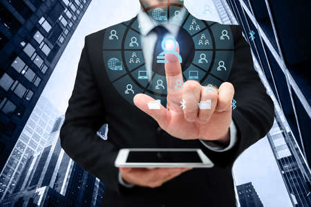 Man In Uniform Standing Holding Tablet And Virtually Tapping Screen. Business Man Carrying Pad Typing And Displaying New Futuristic Technologies.の写真素材