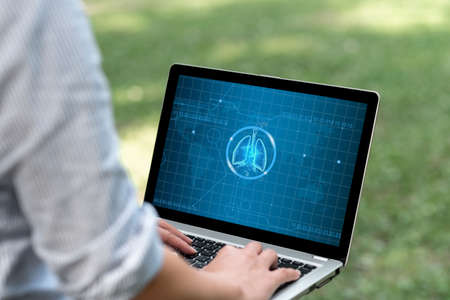 Woman Typing On Laptop In The Park Alone Actively Accomplishing Her Remote Jobs. Girl Doing Projects To Minicomputer Of Her Own Finishing Computer Works.の写真素材