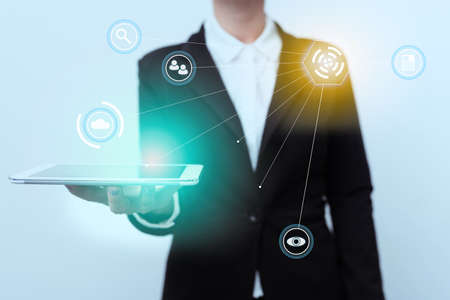 Woman In Uniform Standing And Displaying Mobile Device Using Futuristic Virtual Image Display. Lady In Suit Presenting Phone Modern Virtual Interface Technology.の写真素材