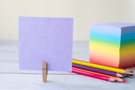 Blank Sticky Note With Laundry Clip Stack Of Colorful Paper Pen Placed On Table. Empty Piece Of Sheet Clipped Beside Pen And Flashy Papers On Desk.の写真素材