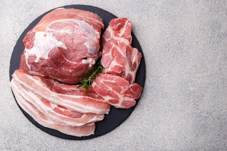 Fresh boneless pork loin with herbs on black stone background close up coopy spaceの写真素材