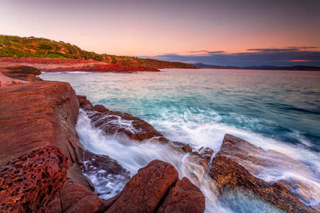 Early morning on the rich red rocky coast of Edenの写真素材