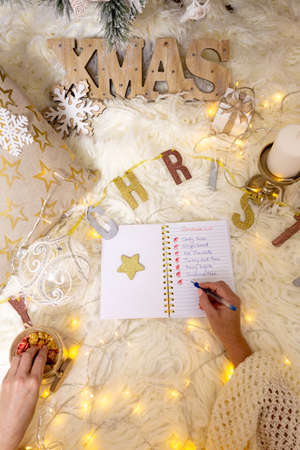 Writing out a Christmas list under the treeの写真素材