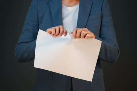 Unsatisfied and angry businesswoman tearing business legal agreement contract paperの写真素材