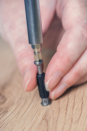 Woman assembling furniture at home on the floor, hand with screwdriverの写真素材
