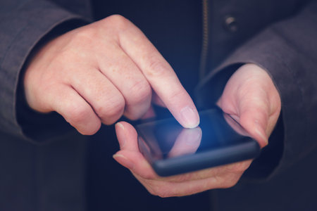 Close up of female hands using mobile phone outdoors, finger pressing touch screen of smartphone electronics deviceの写真素材
