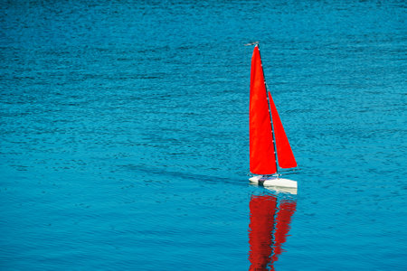 Radio remote control rc sailing yacht boat simulation model in blue waterの写真素材