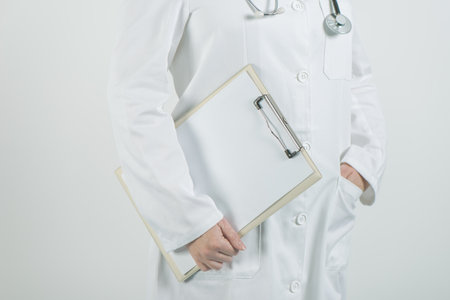 Female doctor posing with clipboard notepad and blank paper as copy space for medical advice, warning, recommendation or suggestion.の写真素材