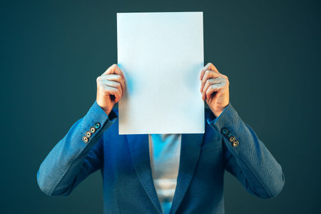 Blank business document paper covering businesswoman's face, copy space for text