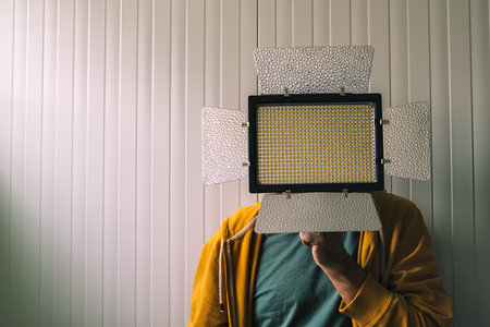 Man posing with led lighting equipment covering his faceの写真素材
