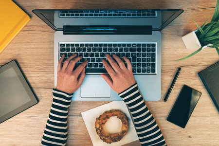 Everyday office life, female hands working on laptop computer - top view of businesswoman typing...