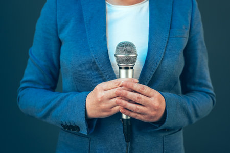 Elegant female journalist conducting business interview or press conference, hand with microphoneの写真素材