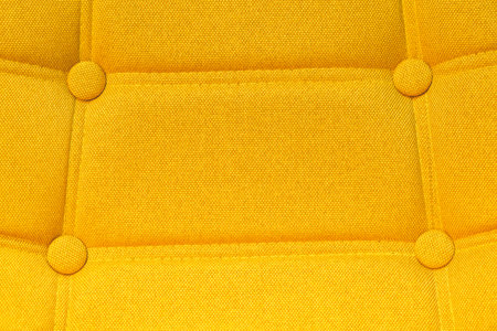 Buttoned chair back support detail, yellow fiber material textureの写真素材